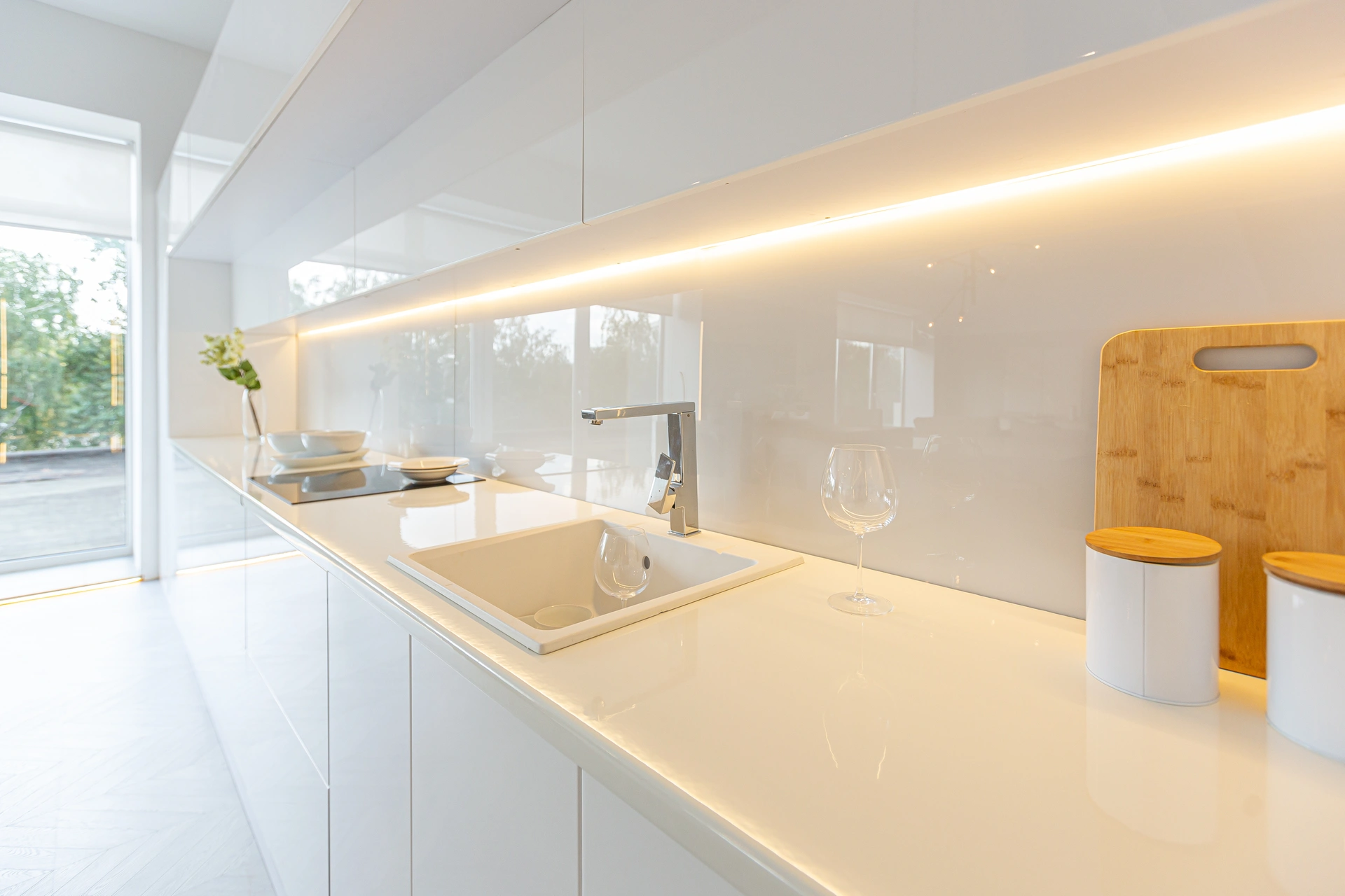 Modern open-concept interior with a fireplace, kitchen bar, dining table, and glossy tiled floors.